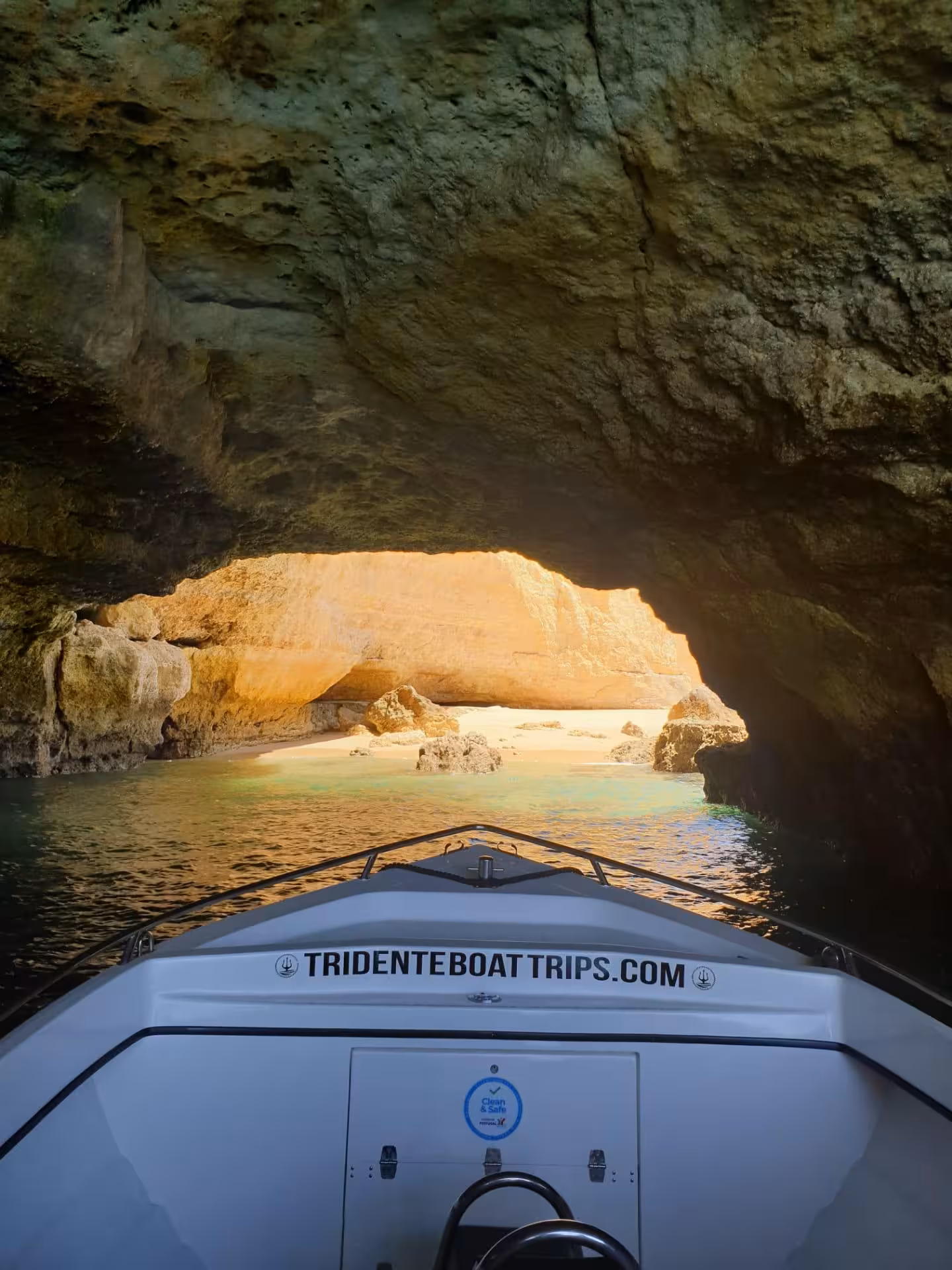 Private boat navigating inside Benagil Cave sea arch revealing a stunning hidden beach in Algarve Portugal