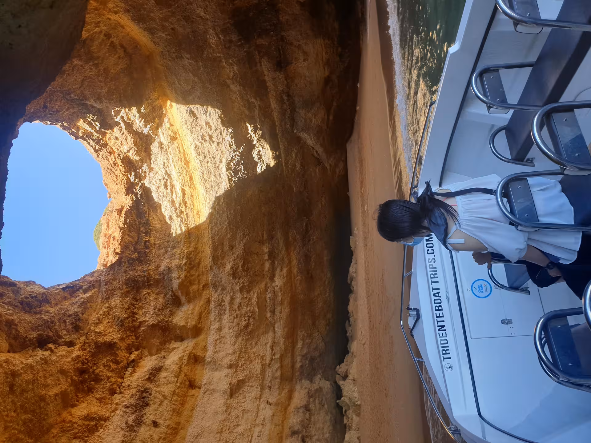 Tourist admiring iconic Benagil Cave skylight opening on a private 1-hour boat tour from Armacao de Pera Portugal