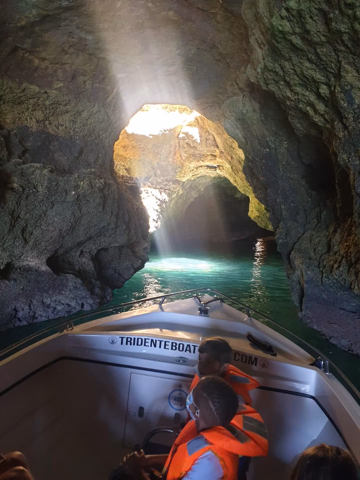 Private Benagil Cave boat tour from Armacao de Pera with sunlight streaming through the iconic cave opening over turquoise waters.
