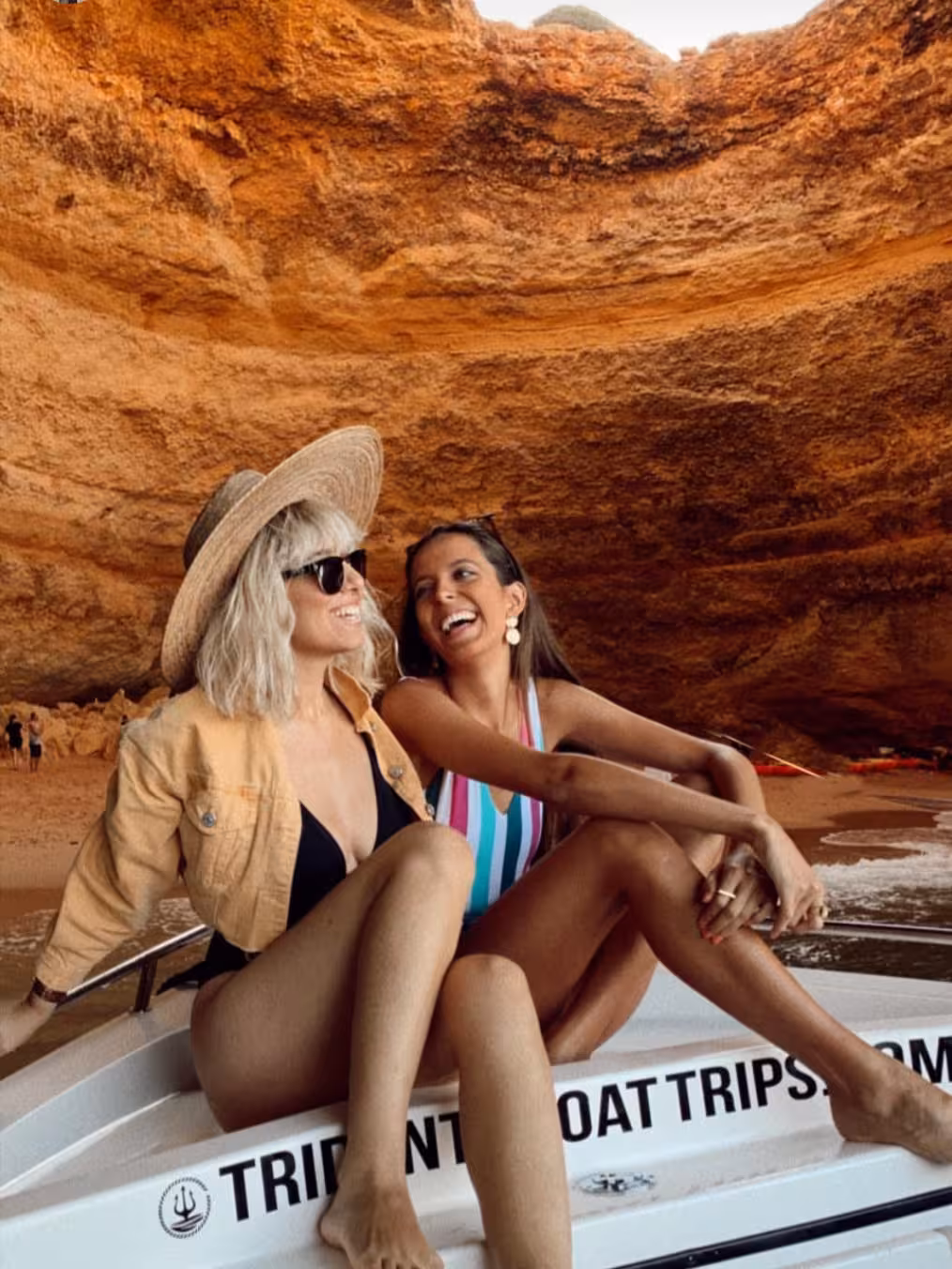 Two happy women smiling inside Benagil Cave on a private deluxe boat tour Algarve Portugal Tridente Trips