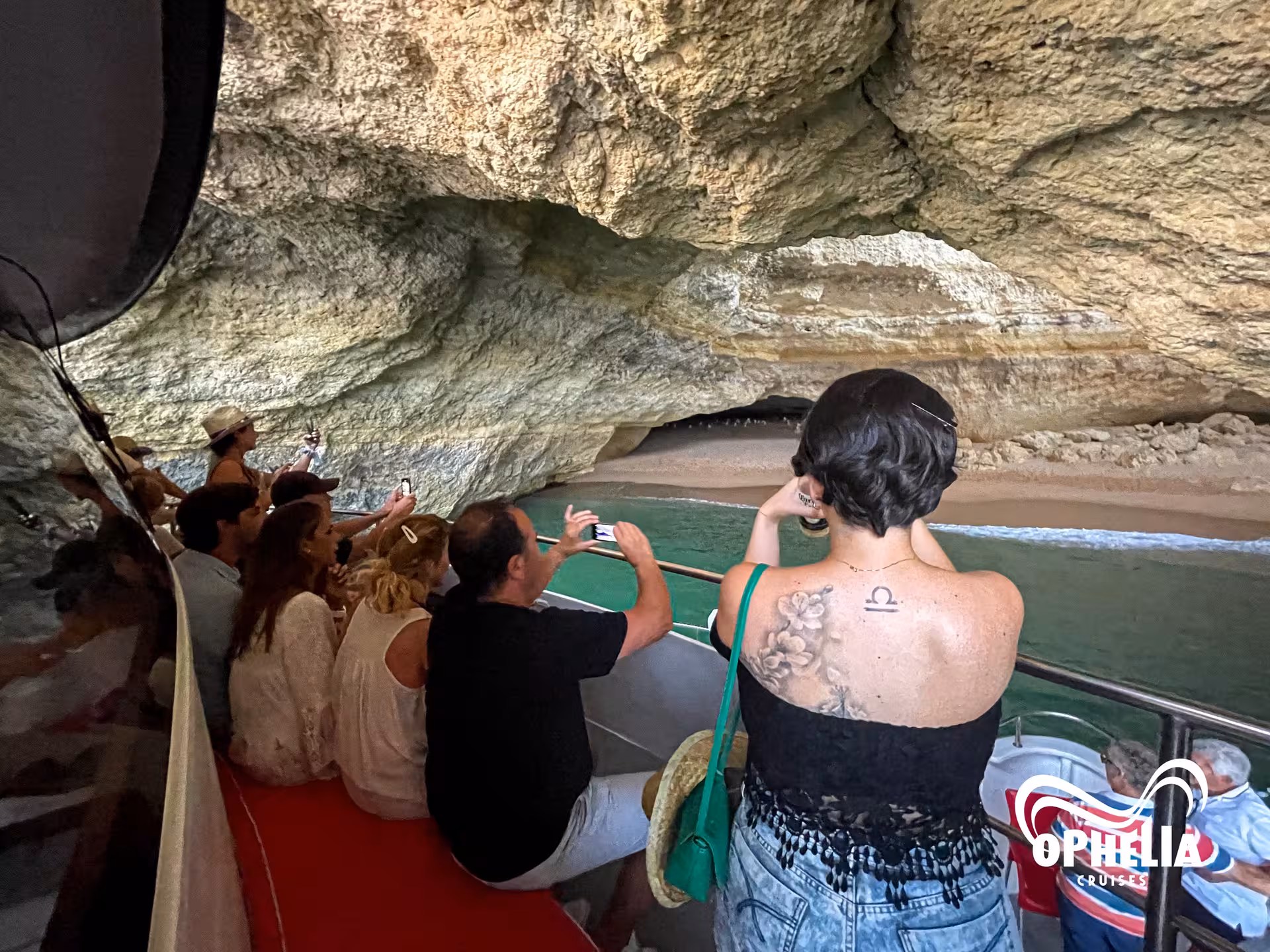 Visitors capturing photos inside the stunning Benagil Cave on the Ophelia sunset tour in Algarve, Portugal.