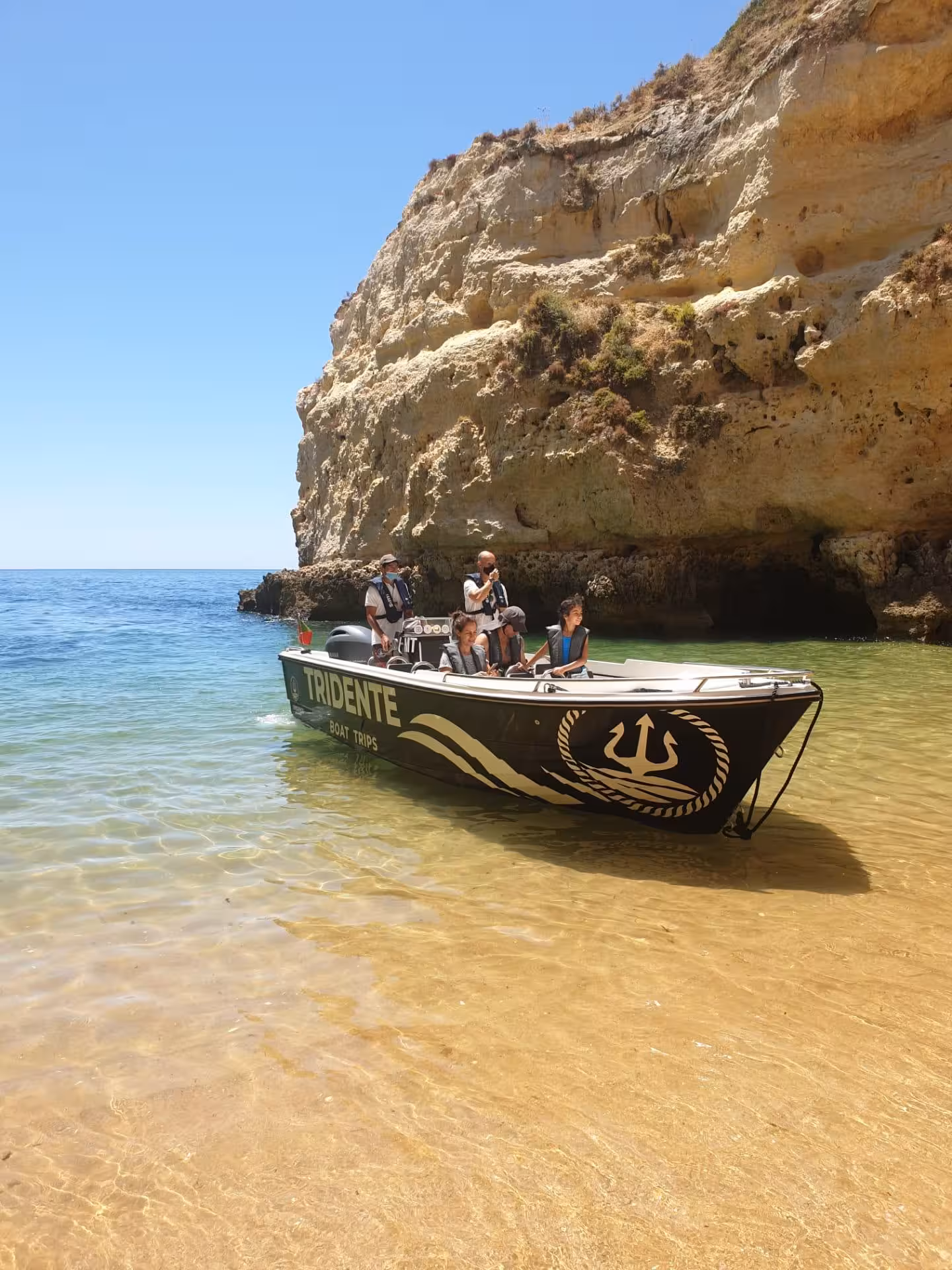 Tridente Boat Trips guided Benagil Cave tour with guests beside golden Algarve cliffs and crystal clear waters