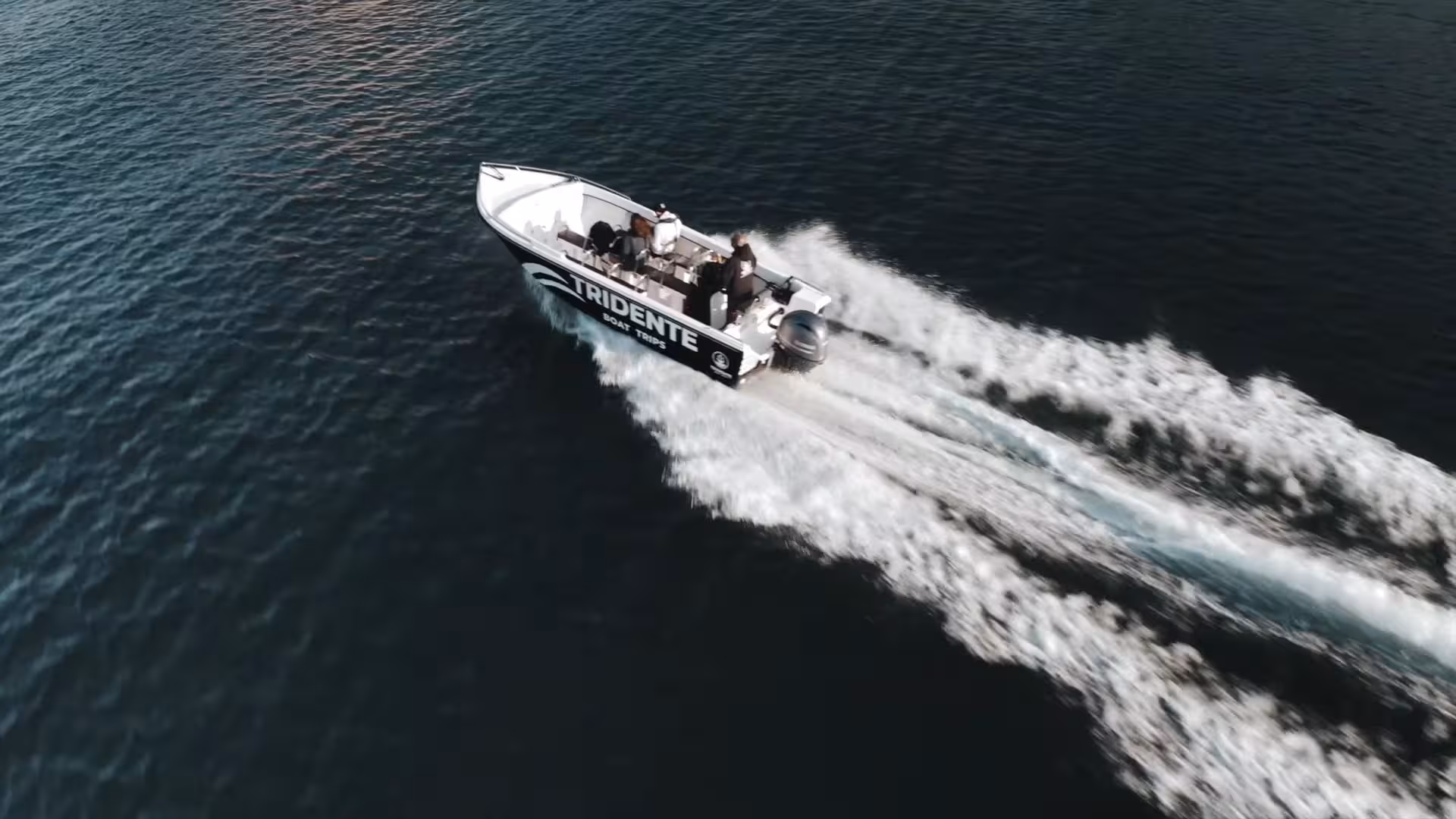 Speedboat from an exclusive Benagil Cave tour cutting across the Algarve coast’s deep blue Atlantic waters at sunrise