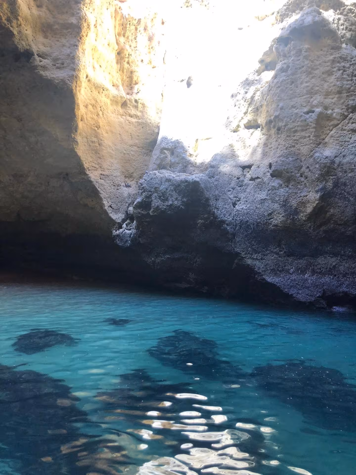 Inside the enchanting Benagil Cave, sunlight illuminates the turquoise waters and rugged rock textures.