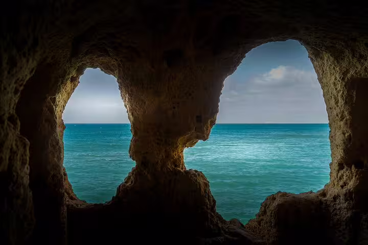 View of the azure ocean through the natural rock formations of Benagil caves on an Algarve private boat tour from Lisbon.
