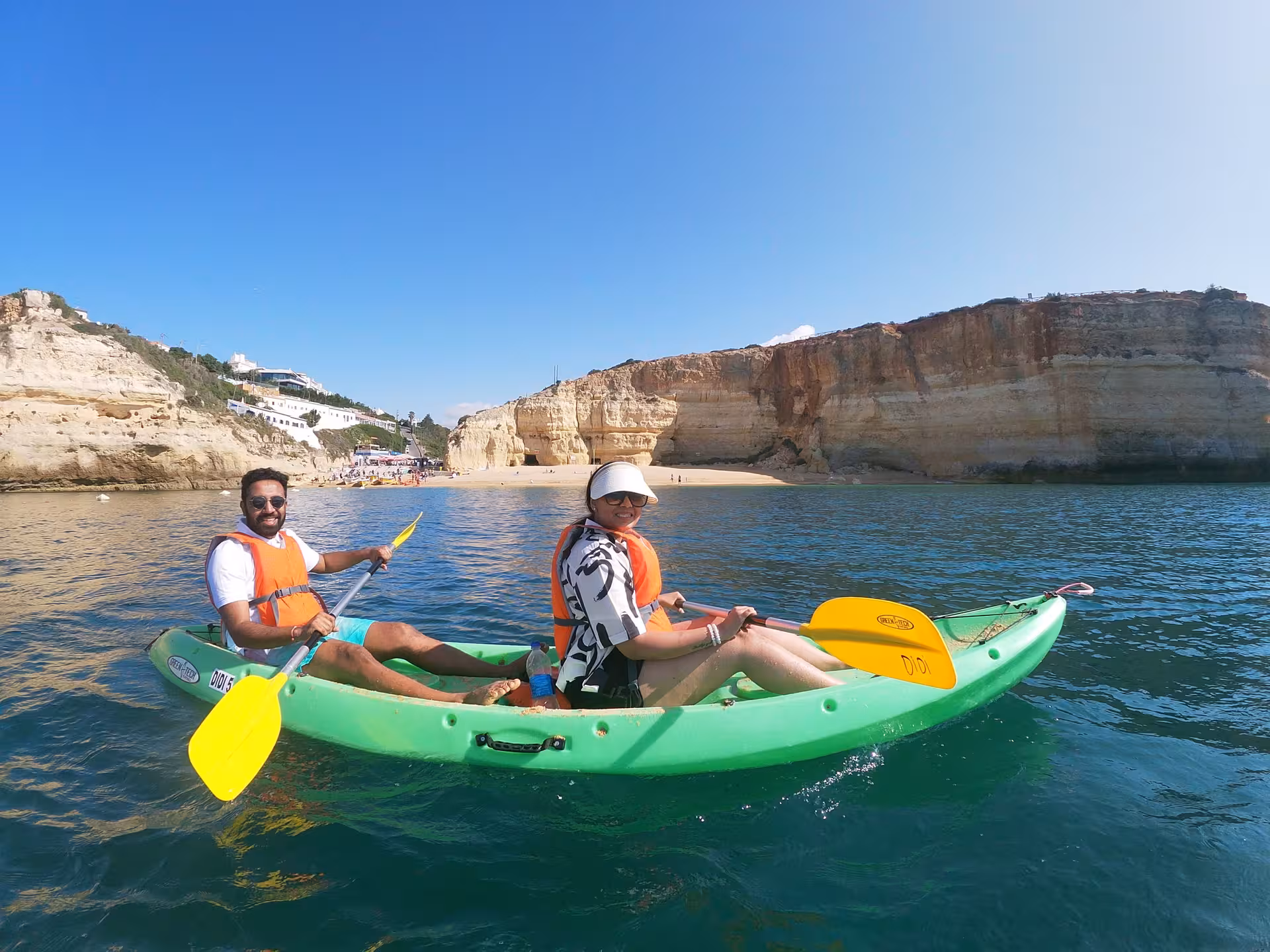 Couple enjoying a Benagil Caves kayak experience off the Algarve coast, paddling by secluded beaches and limestone cliffs