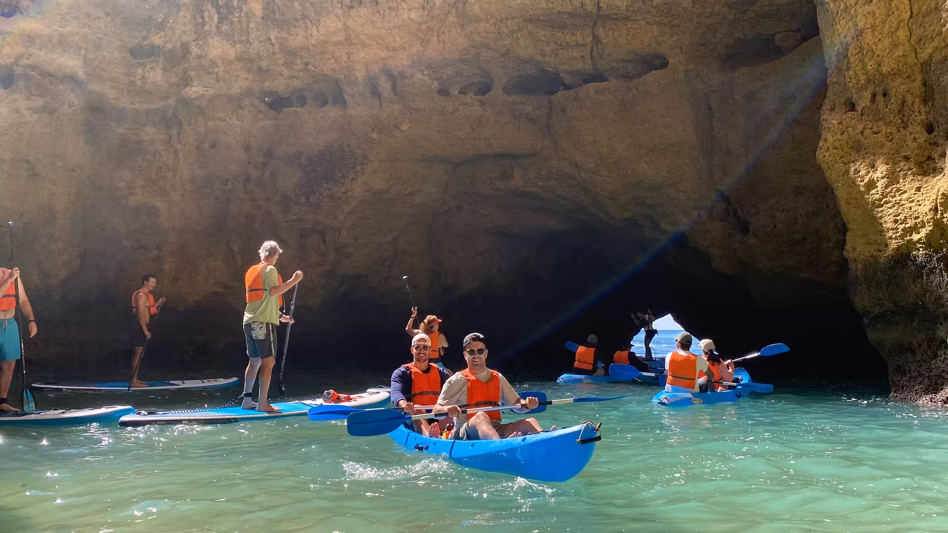 Small group kayaking and paddleboarding into the sunlit Benagil sea caves on a guided Algarve Portugal adventure tour