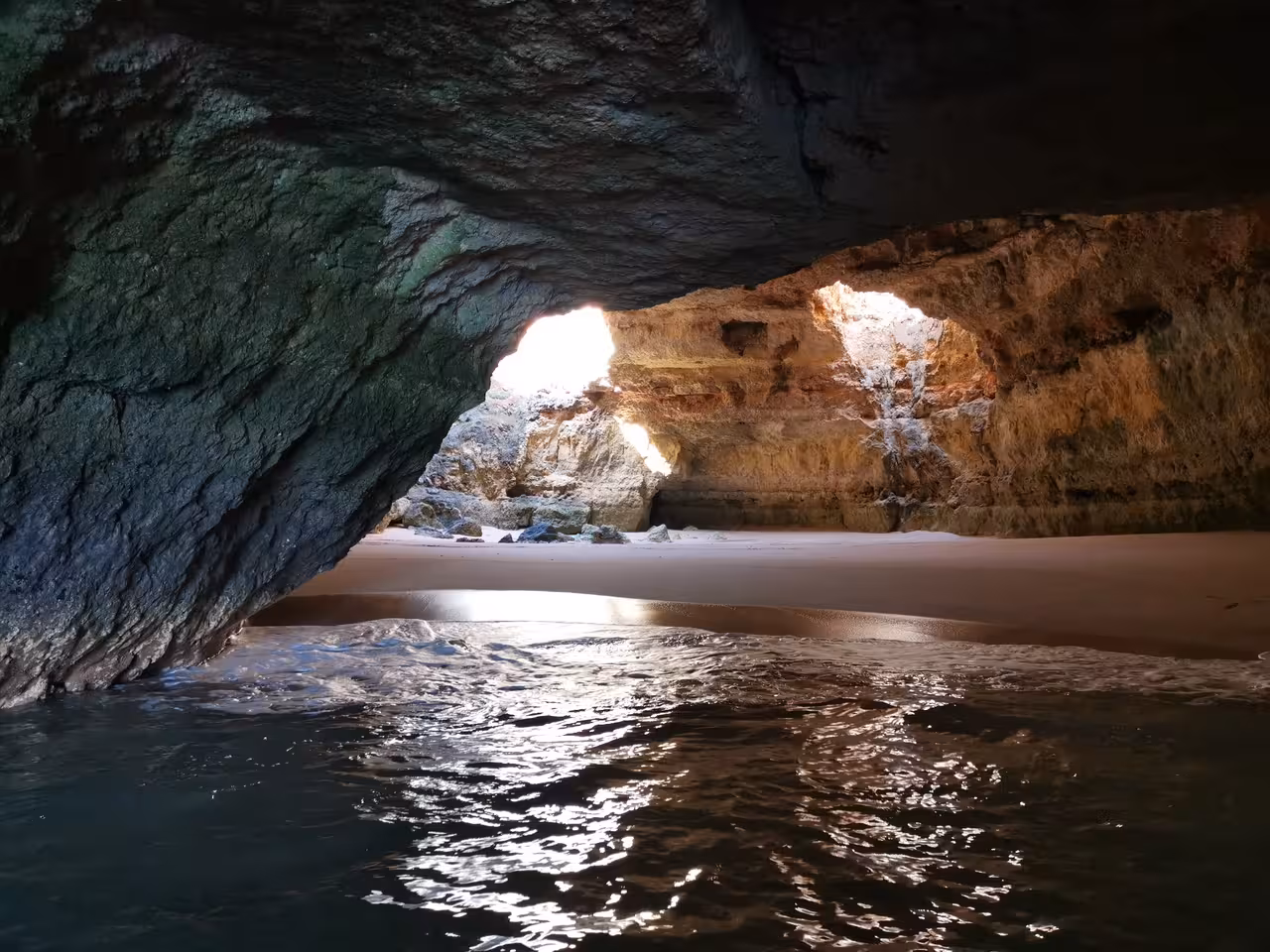 Inside Algarve sea cave with sandy beach and light at the entrance, Benagil Caves boat trip from Albufeira Marina