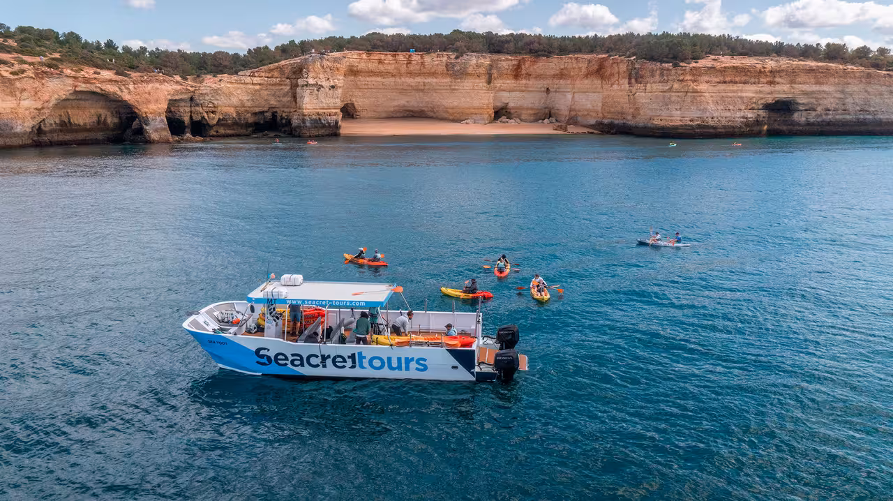 Benagil kayak tour with support boat on Algarve coast, paddling to sea caves and cliffs near Praia de Benagil