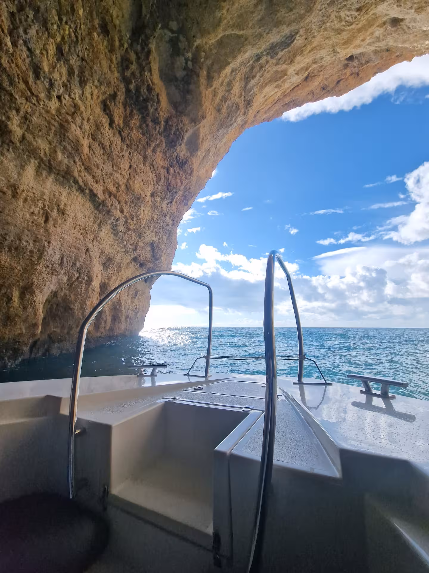 View from the tour boat entering Benagil sea cave, with rugged cliffs framing the bright blue Atlantic Ocean in the Algarve