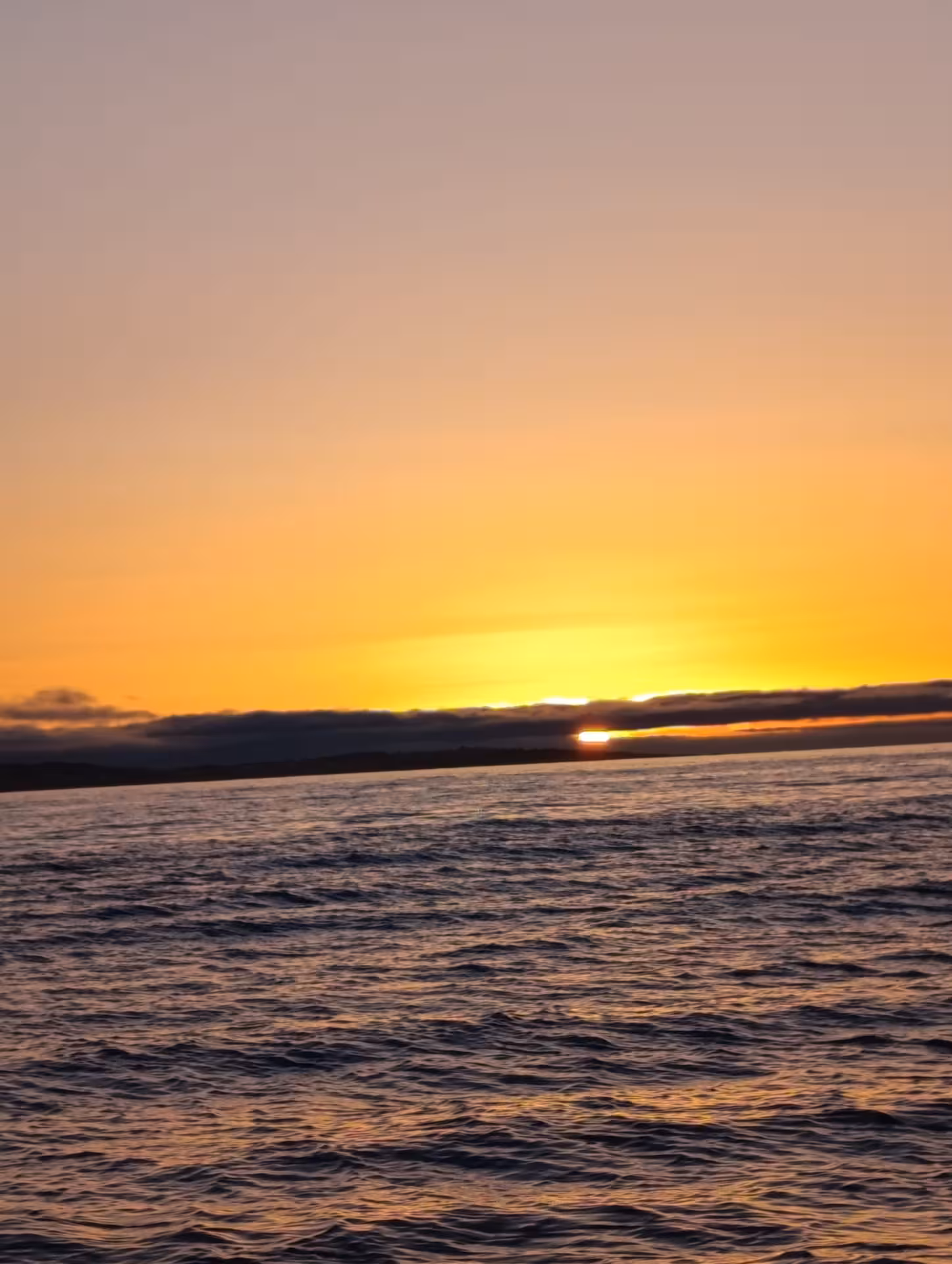 Golden sunrise over the Atlantic Ocean near Benagil cave with rippling waves on the Algarve coast Portugal