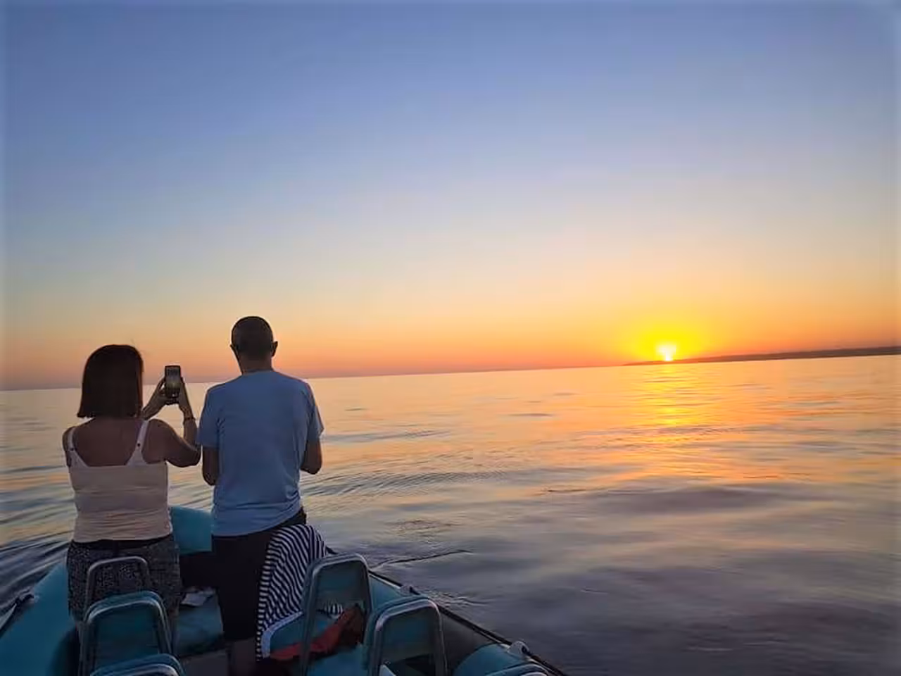 Sunset boat cruise from Albufeira Marina with guests watching the Algarve coast on a scenic Benagil journey