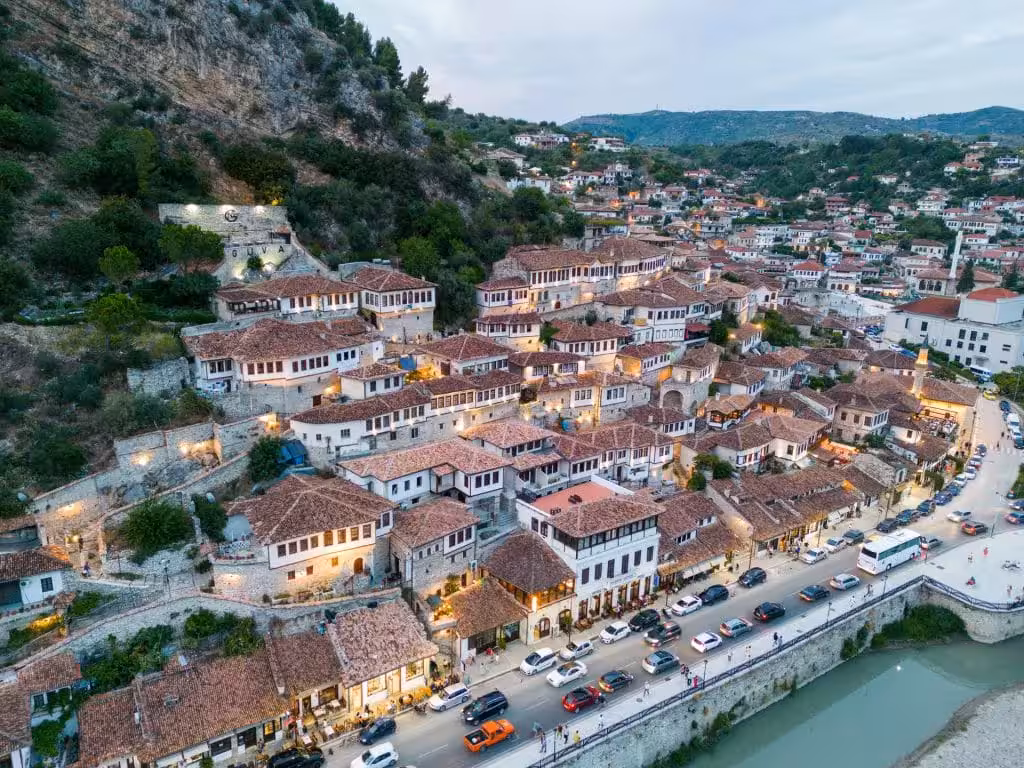 Discover the charming hillside town of Berat, Albania, with its iconic Ottoman architecture and vibrant evening lights.