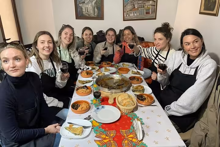 A group of participants raising glasses and enjoying a traditional meal at the Berat Cooking Class in Albania.