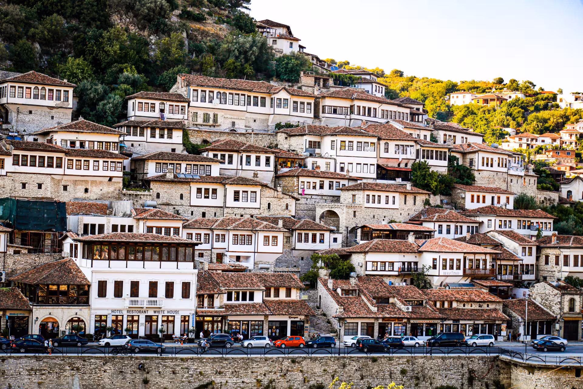 Panoramic view of Berat's historic white Ottoman houses cascading down the hillside, a UNESCO World Heritage Site.