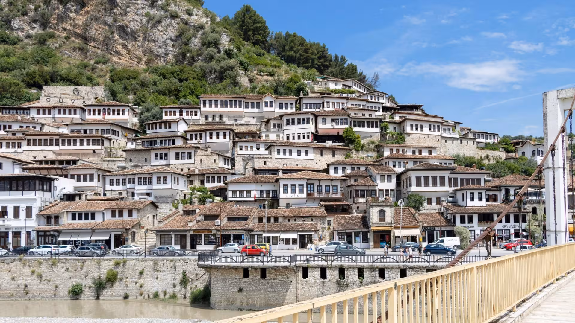 Experience the picturesque view of Berat's traditional white Ottoman houses cascading down the hillside by the river.