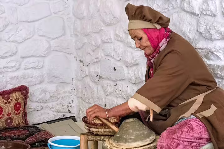 Berber woman weaving traditional craft in Marrakech medina workshop, authentic cultural stop on old city walking tour