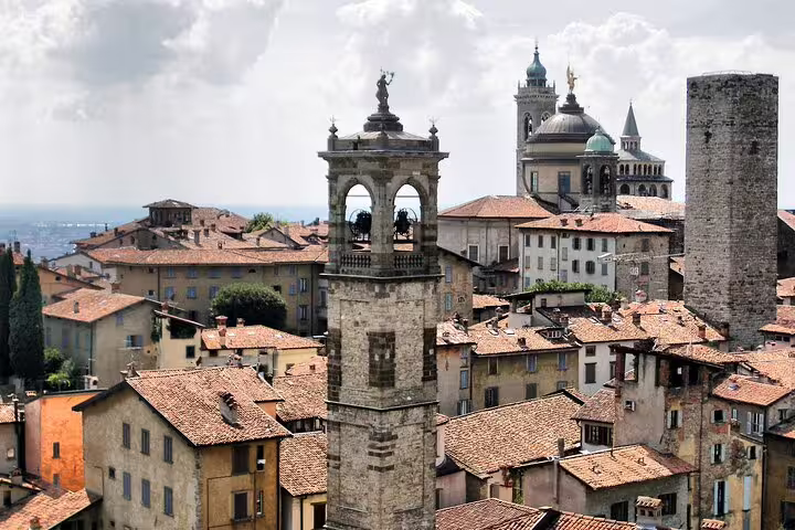 Close-up of Bergamo Alta bell tower, stone buildings and cathedral domes featured on a 2.5-hour private walking tour