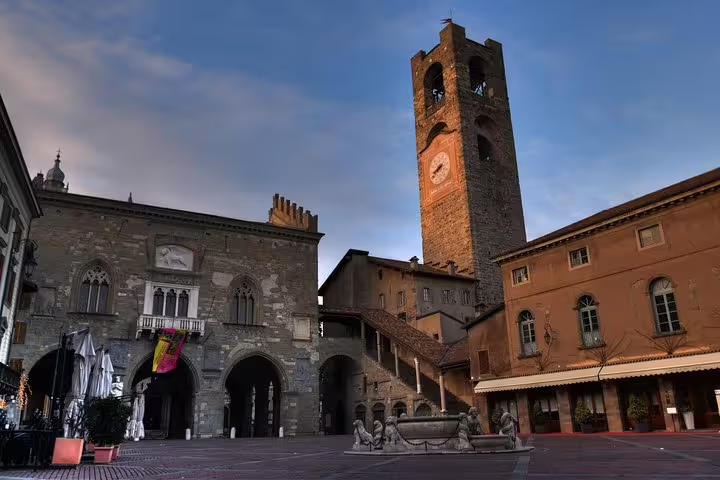 Evening view of Piazza Vecchia and the historic Civic Tower in Bergamo Alta, featured on a 2.5-hour private walking tour