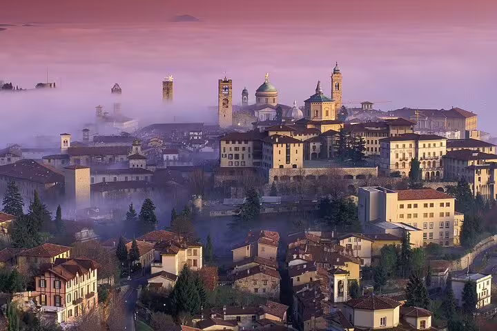 Panoramic skyline of misty Bergamo Alta at dusk, historic highlights seen on a 2.5-hour private Bergamo walking tour