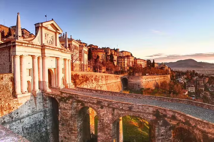 Sunset over Bergamo Alta’s Venetian walls and Porta San Giacomo, a highlight stop on the 2.5-hour private walking tour