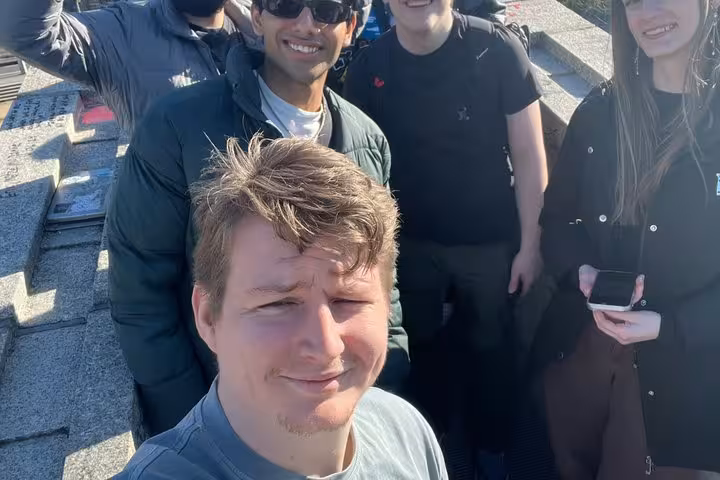 Group of tourists smiling together outdoors on a rooftop during a Berlin walking tour