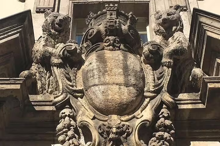 Stone heraldic coat of arms with bear supporters and mural crown on historic Berlin building facade
