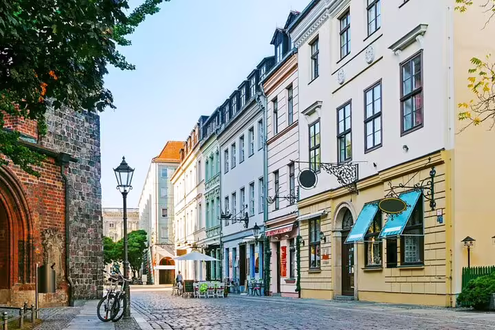Cobblestone street with colorful historic buildings and medieval stone church in Berlin old town