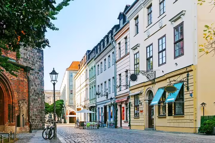 Cobblestone street in Berlin's historic old town with colorful buildings and a medieval brick church