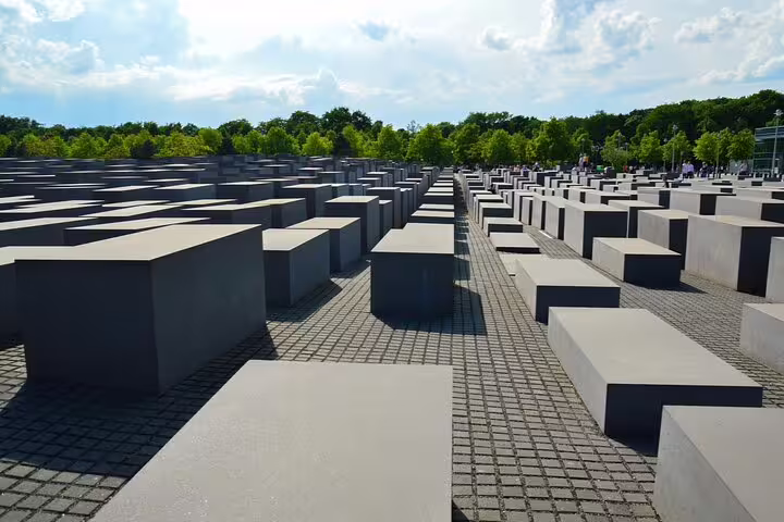 Rows of grey concrete stelae at the Holocaust Memorial in Berlin on a sunny day
