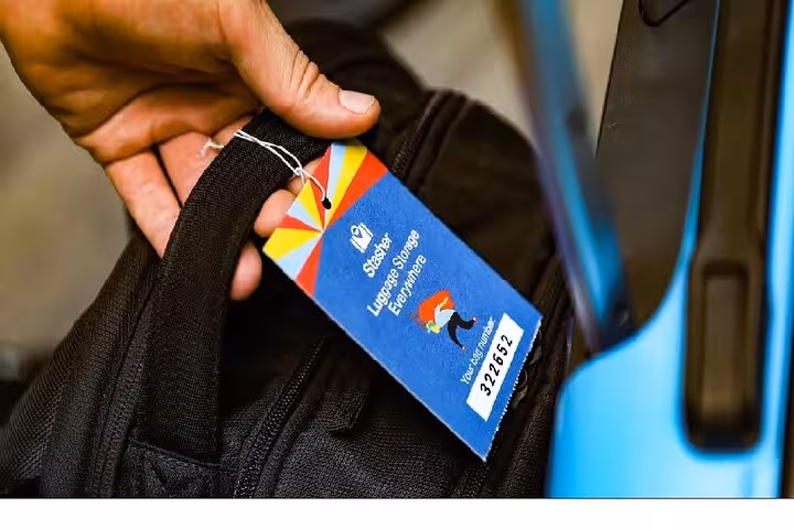 Close-up of suitcase handle with Berlin luggage storage tag, secure bag drop service for travelers