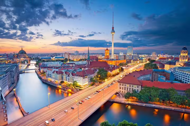 Aerial panoramic view of Berlin skyline at sunset with the TV Tower, River Spree, and illuminated city streets