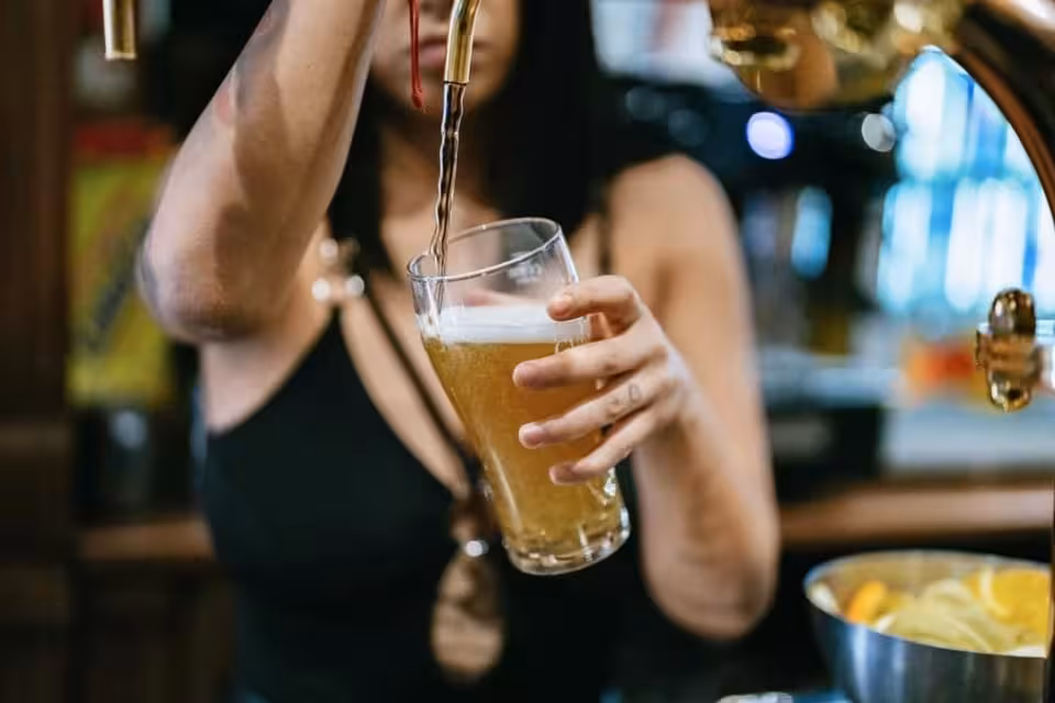 Bartender pouring draft beer in Berlin bar during Ludwig’s queer pub crawl with VIP club entry