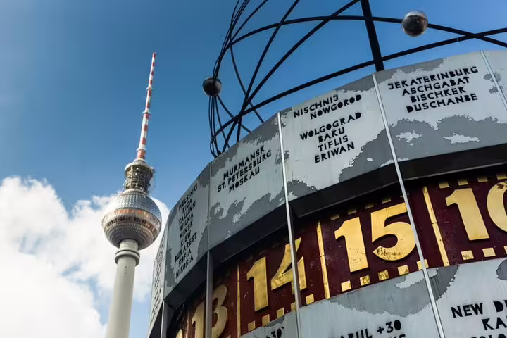 Weltzeituhr world clock and Berlin TV Tower Fernsehturm at Alexanderplatz under blue sky