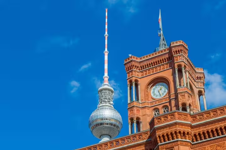 Berlin TV Tower and red brick Rotes Rathaus clock tower against blue sky
