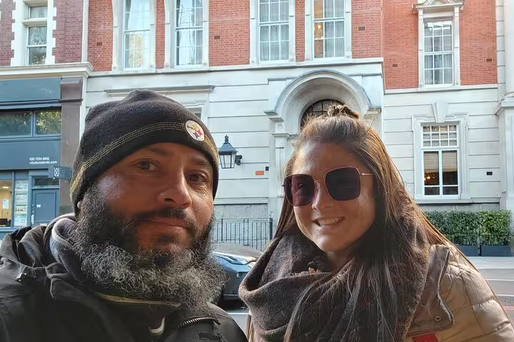 Couple taking a selfie on a Bermondsey street with a red brick building behind them