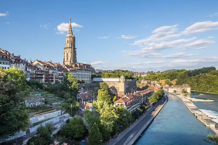 Bern Cathedral tower rising above old town buildings along the Aare River, Switzerland
