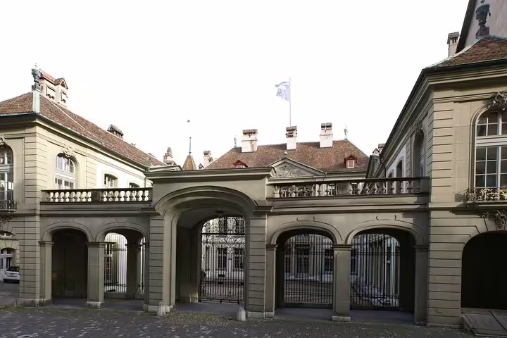 Historic baroque palace gate with iron gates and flag in Bern, Switzerland