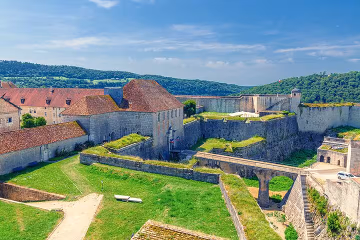 Aerial view of Besancon Citadel fortress walls, green courtyard, and surrounding hills in France