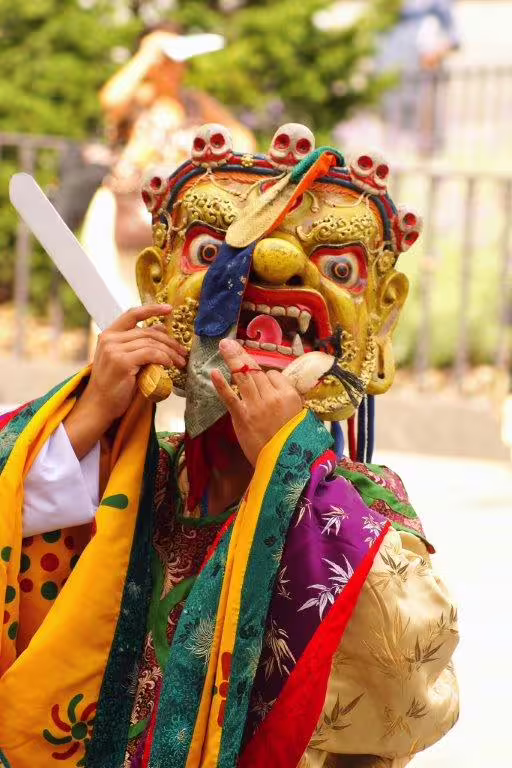 Traditional Bhutanese masked dancer in vibrant costume, showcasing cultural heritage on the 12-day Bhutan tour.
