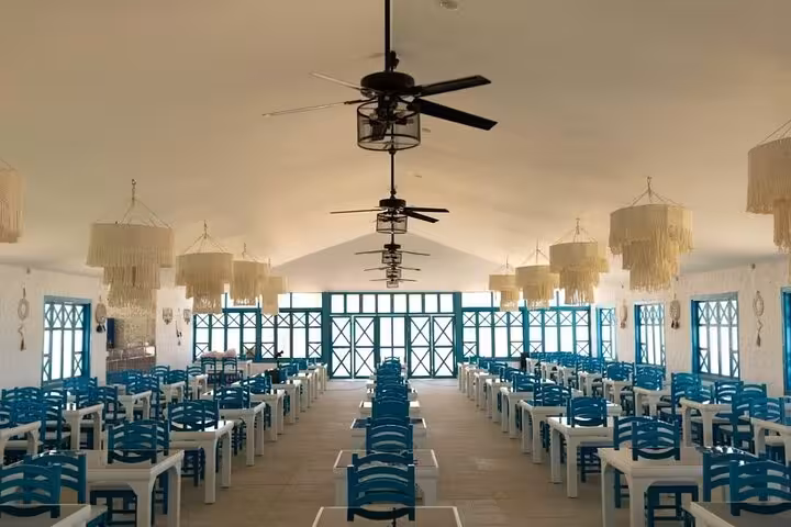 Bianca Island restaurant dining hall with blue chairs, included lunch stop on Utopia Island tour from Hurghada