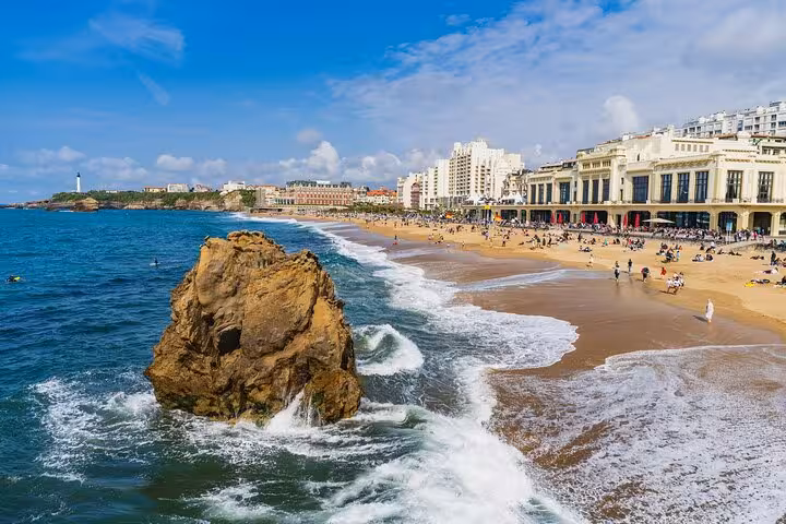 Beautiful sandy beach in Biarritz with waves crashing against rocks, offering a picturesque setting for a coastal city walk.