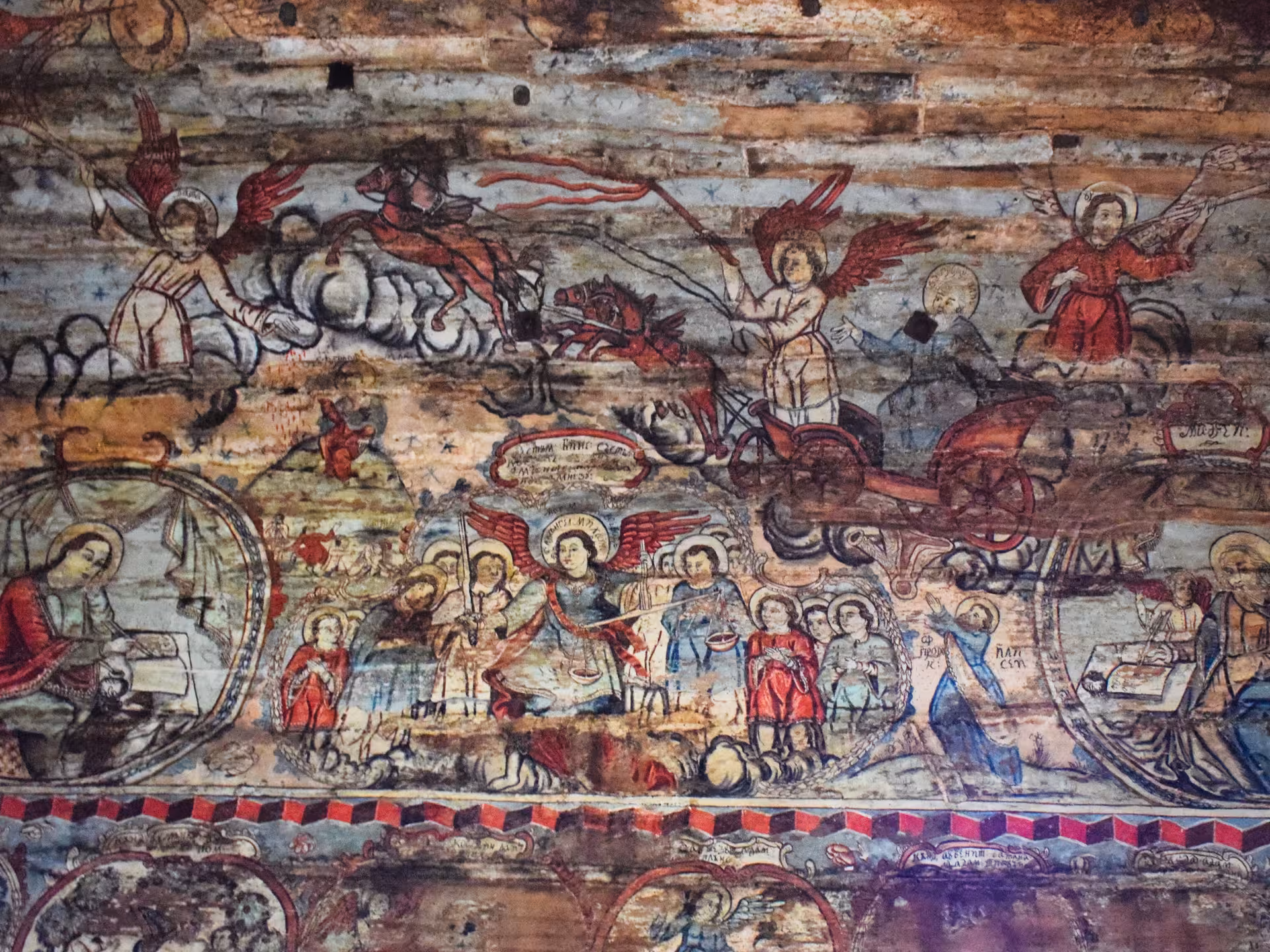 Detailed biblical scene fresco with angels and chariots painted on wooden ceiling of Maramures UNESCO church