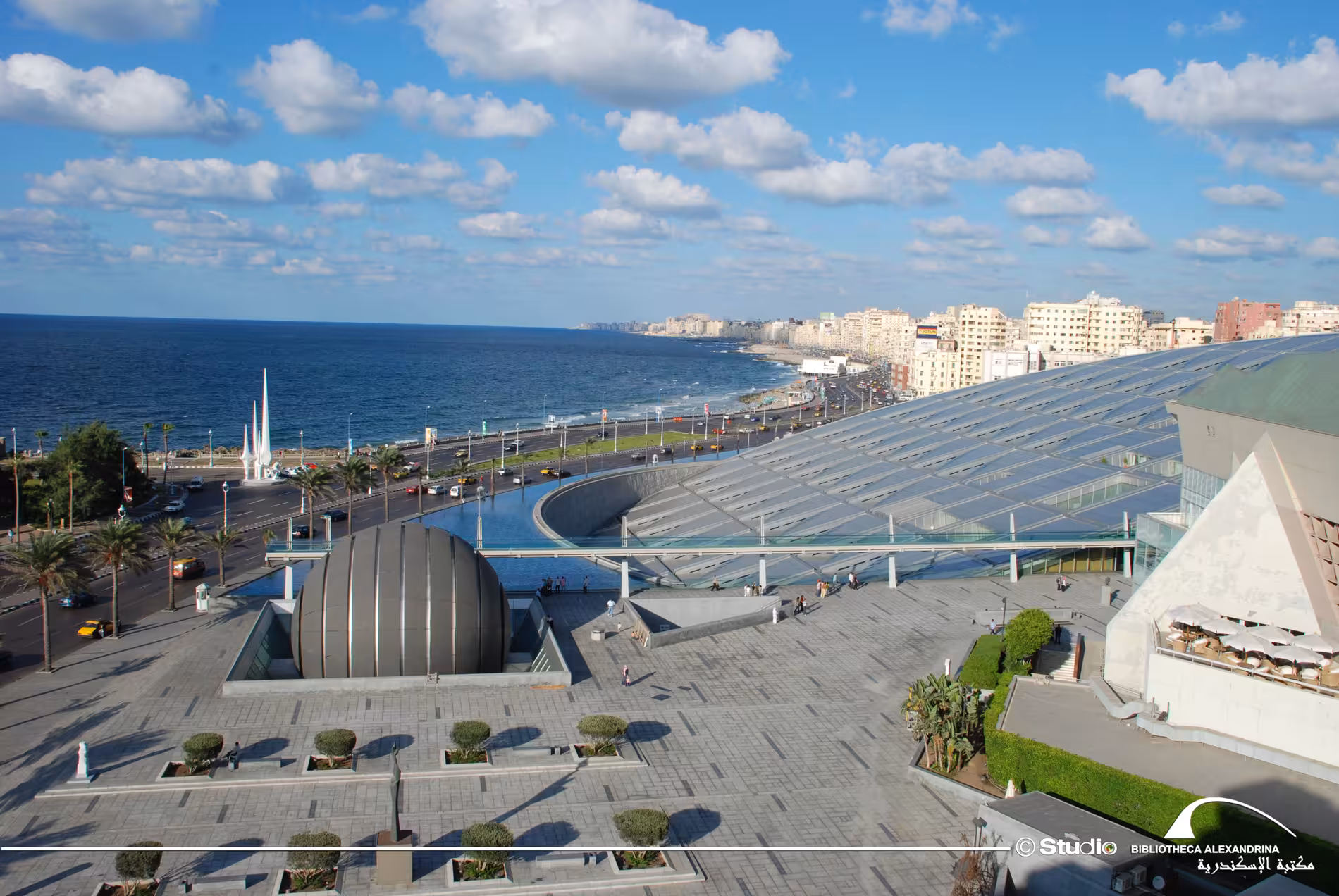 Aerial view of Bibliotheca Alexandrina's iconic tilted glass roof along Alexandria's Mediterranean corniche