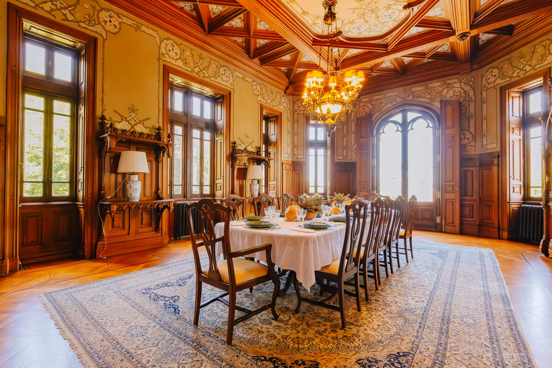Elegant dining room at Biester Palace Sintra featuring ornate carved wood ceiling and chandelier