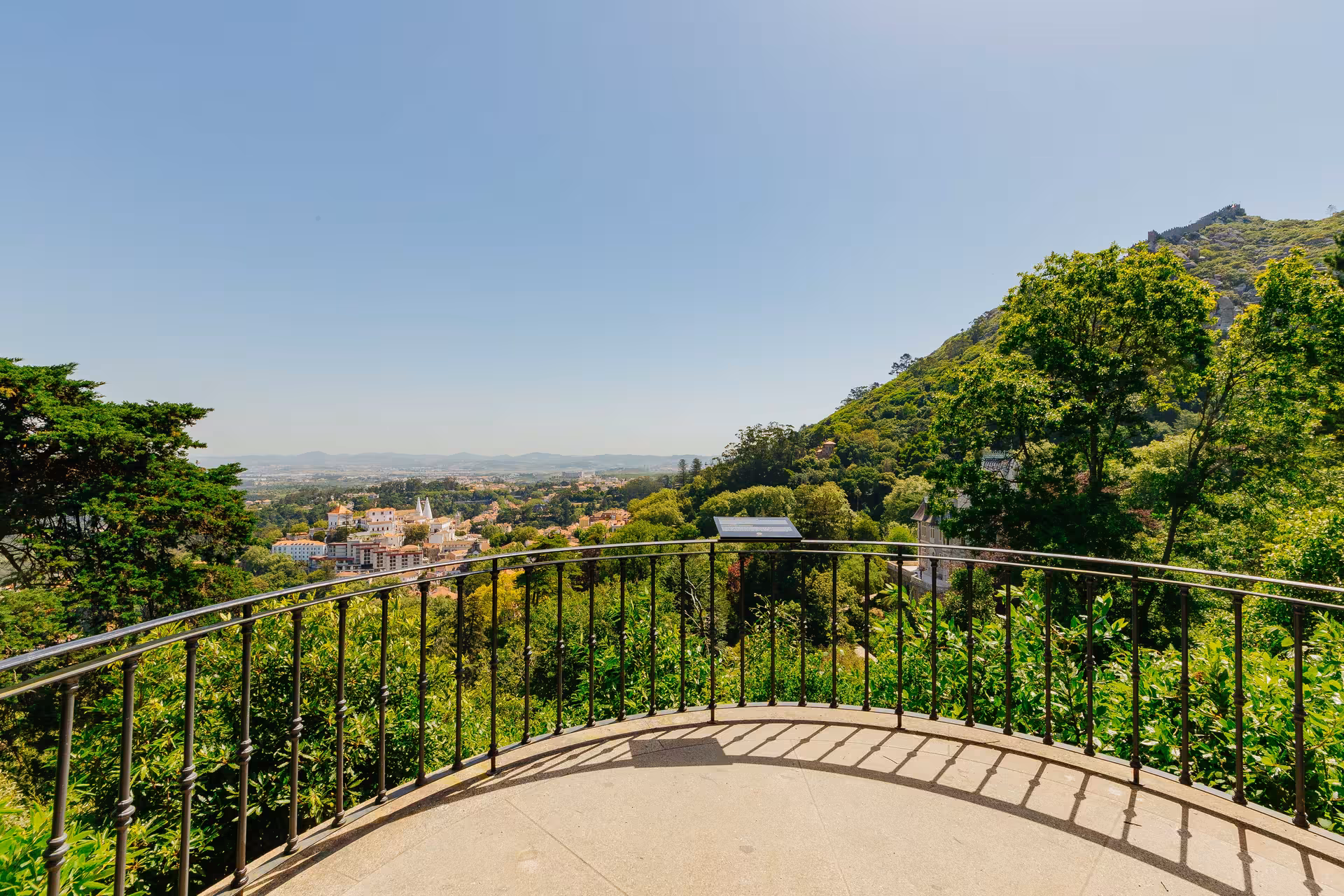 Panoramic viewpoint at Biester Palace Sintra with iron railing overlooking lush green hills and town