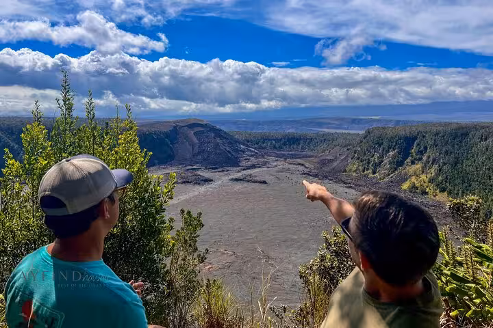 Tourists admire and point at the expansive volcanic crater view on Hawaii's Big Island group tour.