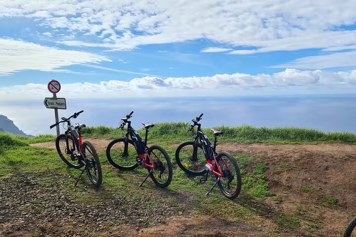 Four bikes parked on a scenic coastal trail in Madeira, ideal for adventure enthusiasts exploring the island's breathtaking views.