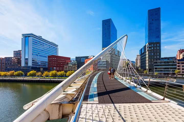 Contemporary bridge in Bilbao with city skyline, perfect for exploring on a private guided walking tour.