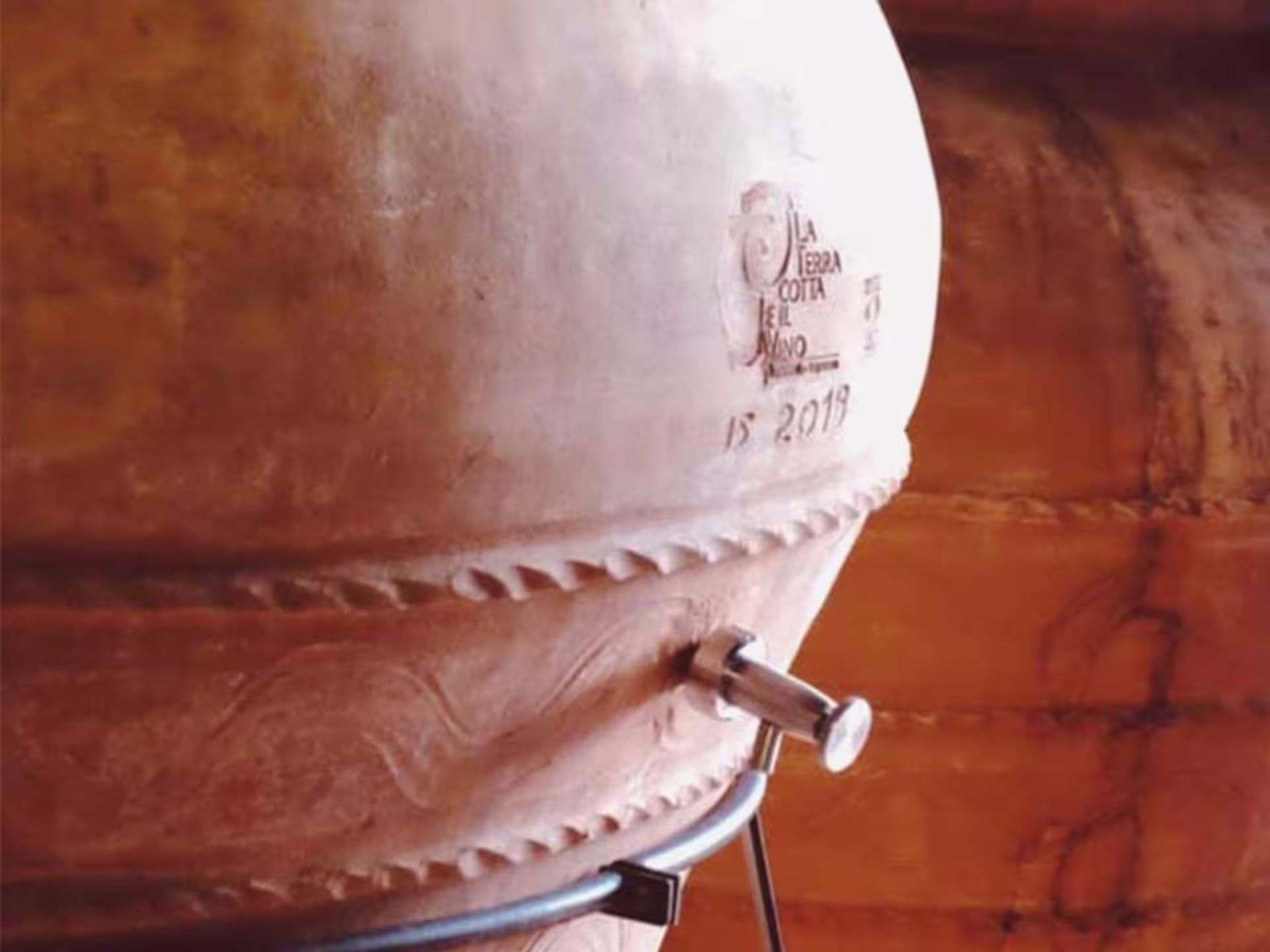 Terracotta wine fermentation vessel used in biodynamic winemaking at a Lucca vineyard tour.